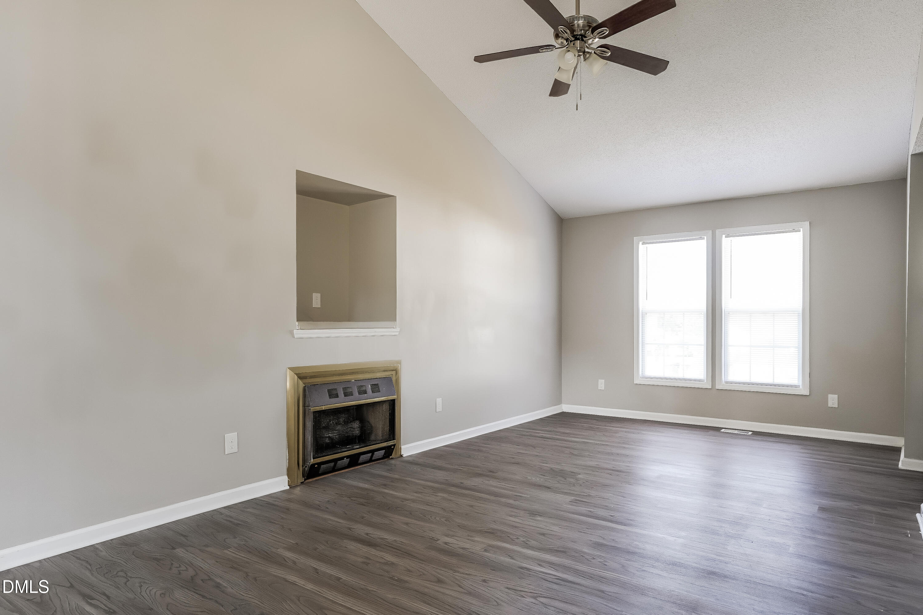 1410 Mandolin Place Zebulon, NC 27597 - Photo 2 of 16 an empty room with wooden floor a ceiling fan and windows