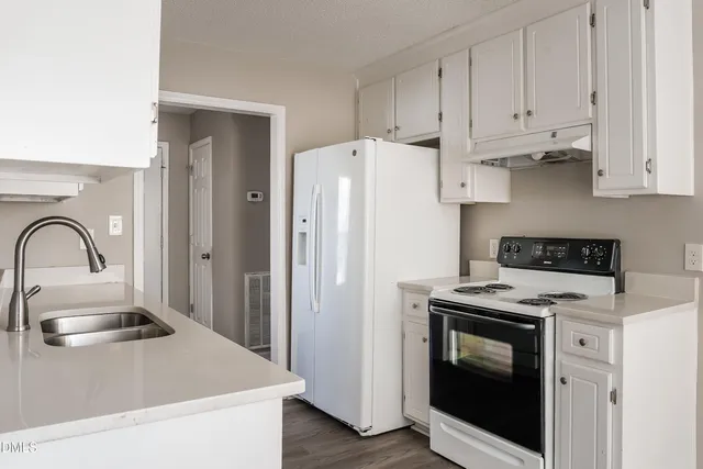 a kitchen with stainless steel appliances granite countertop a stove a refrigerator and a sink