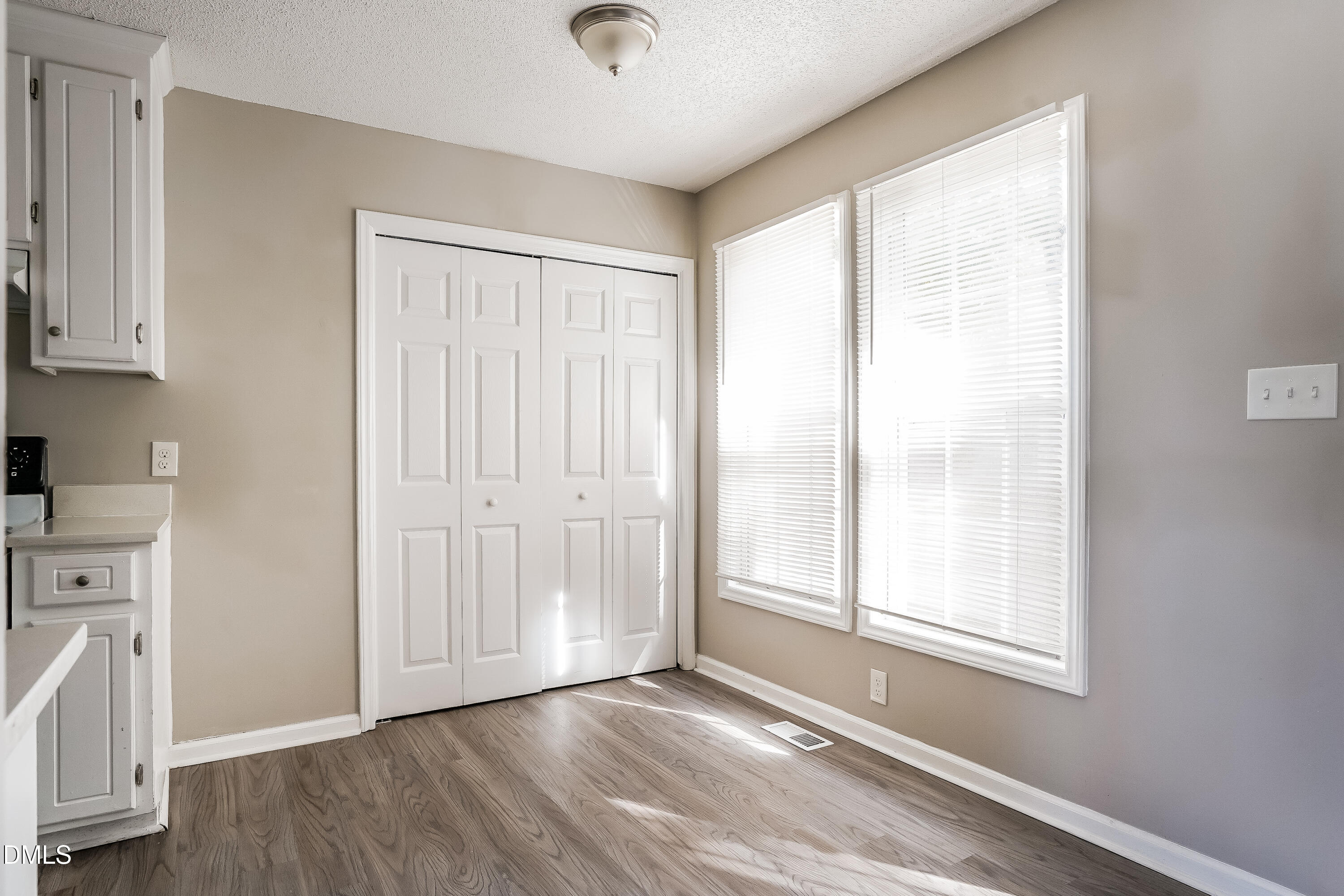1410 Mandolin Place Zebulon, NC 27597 - Photo 10 of 16 an empty room with wooden floor and windows
