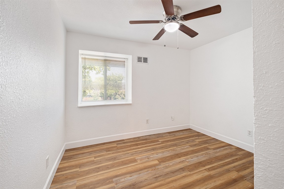 2217 Mission Hill Drive, Unit C Austin, TX 78741 - Photo 11 of 17 an empty room with a window and a ceiling fan