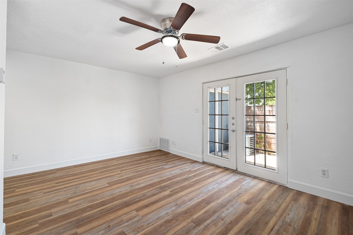 2217 Mission Hill Drive, Unit C Austin, TX 78741 - Photo 4 of 17 a view of an empty room with a window and wooden floor