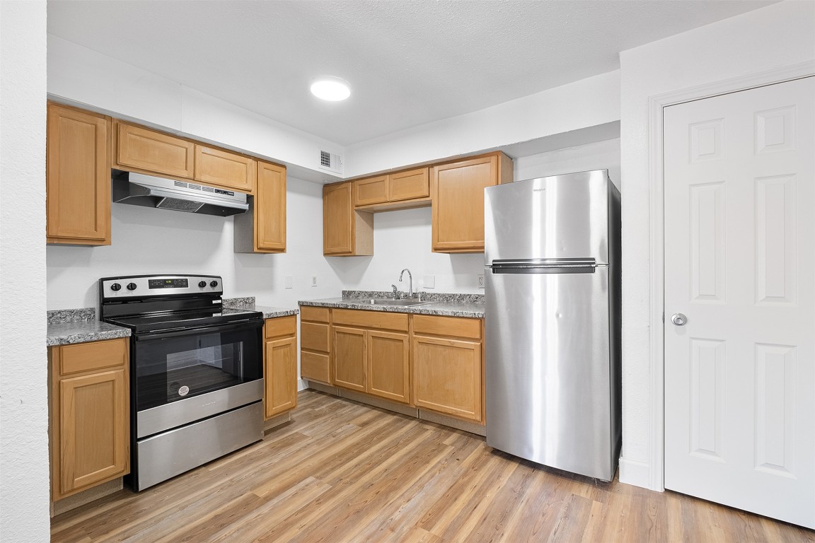 2217 Mission Hill Drive, Unit C Austin, TX 78741 - Photo 7 of 17 a kitchen with stainless steel appliances a stove a refrigerator and a hard wood floor