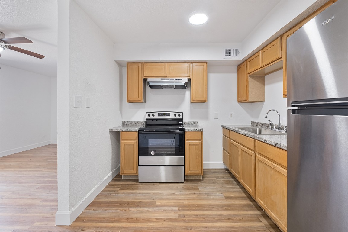 2217 Mission Hill Drive, Unit C Austin, TX 78741 - Photo 8 of 17 a kitchen with granite countertop a refrigerator and a stove