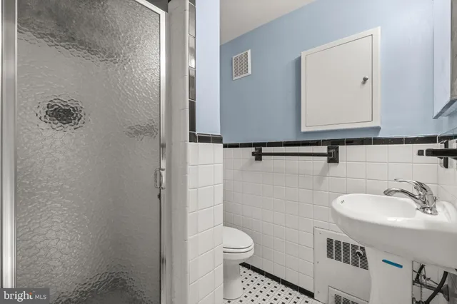 a bathroom with a granite countertop toilet sink and mirror