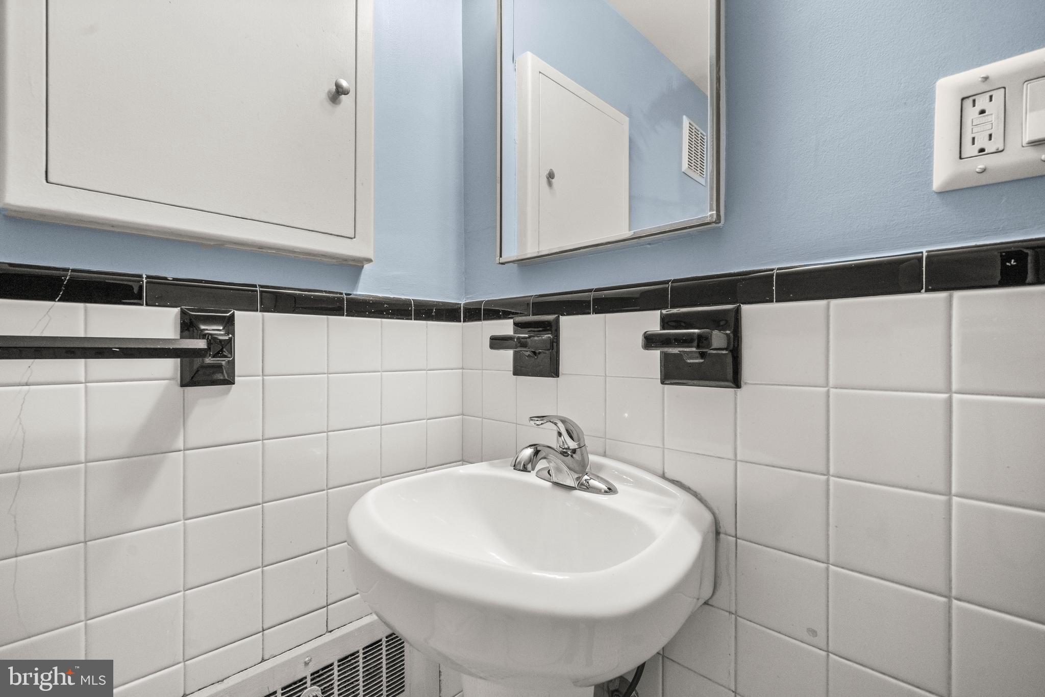 3601 Greenway, Unit 101 Baltimore, MD 21218 - Photo 21 of 32 a bathroom with a sink and a mirror