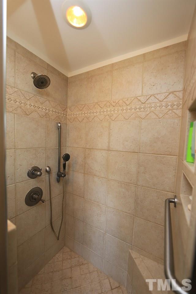 7905 Hardwick Drive Raleigh, NC 27615 - Photo 16 of 26 Tile shower with hand held shower and one on the wall, bench, nooks for shampoo!