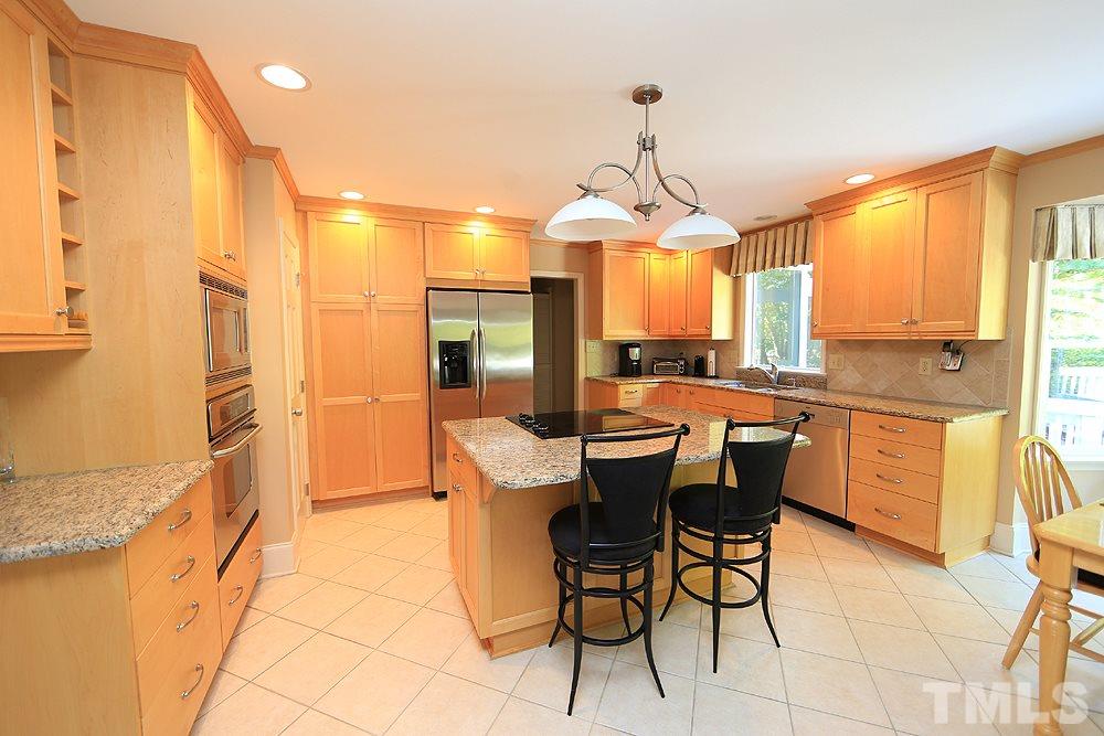 7905 Hardwick Drive Raleigh, NC 27615 - Photo 4 of 26 Remodeled kitchen features quality light wood cabinetry, center island, pantry with pull out shelving, tons of storage.