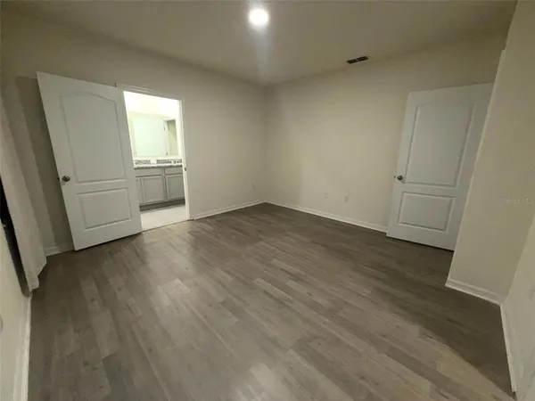 a view of a room with wooden floor and electronic appliances