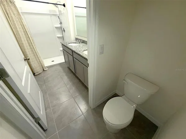 a bathroom with a toilet and a shower