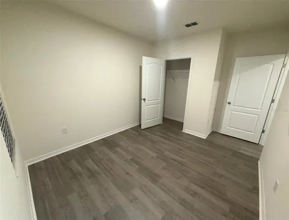 a view of a room with wooden floor and white doors