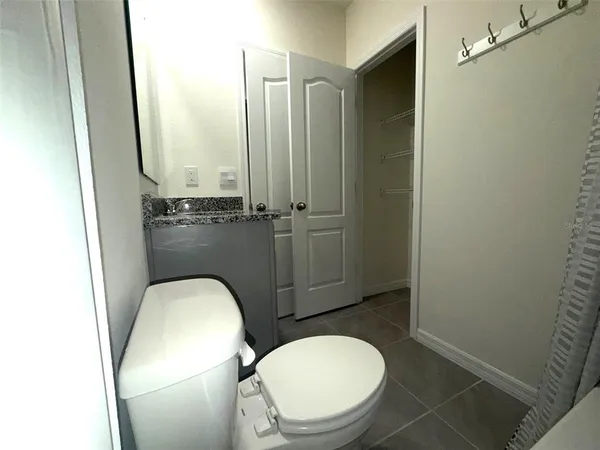 a bathroom with a toilet mirror vanity and tub