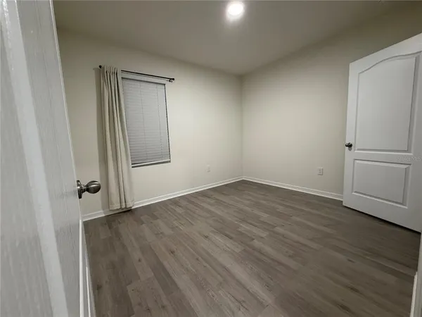 an empty room with wooden floor and closet