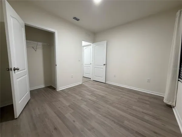 an empty room with wooden floor and white doors