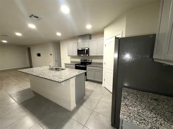 a kitchen with stainless steel appliances granite countertop a refrigerator and a stove