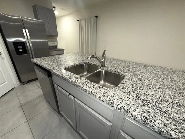 a kitchen with stainless steel appliances granite countertop a sink and a refrigerator