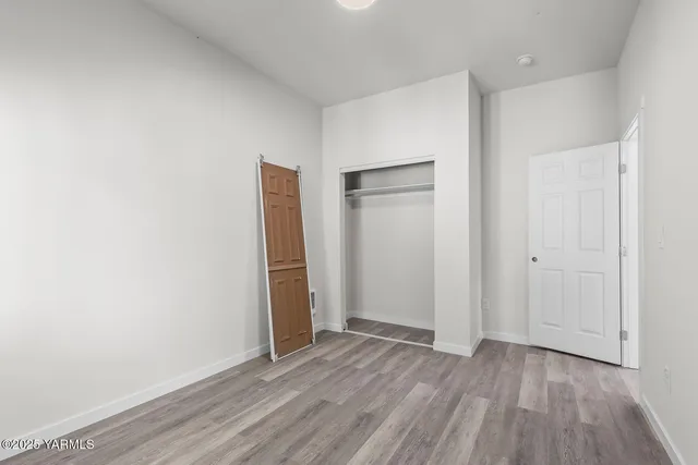 an empty room with wooden floor and closet