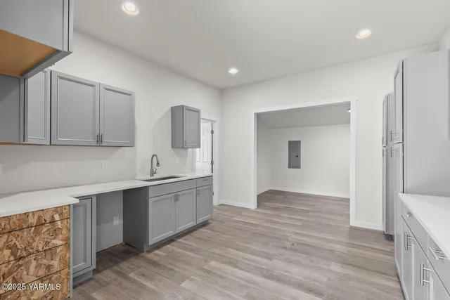 a kitchen with stainless steel appliances granite countertop a sink and cabinets with wooden floor