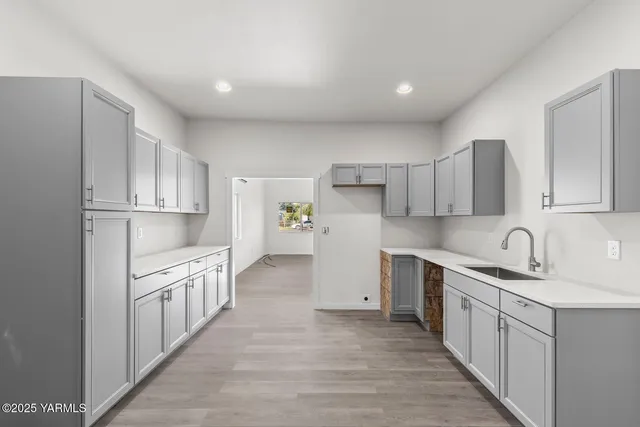 a kitchen with white cabinets sink and stove