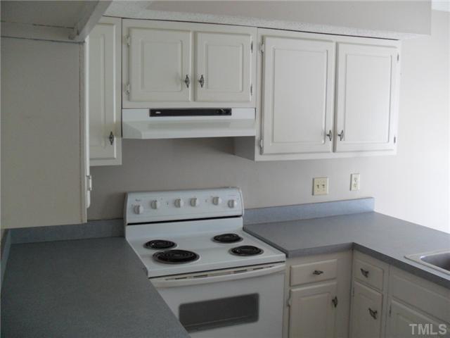 1304 Seaton Road, Unit T2 Durham, NC 27713 - Photo 5 of 8 a kitchen with white cabinets and white appliances