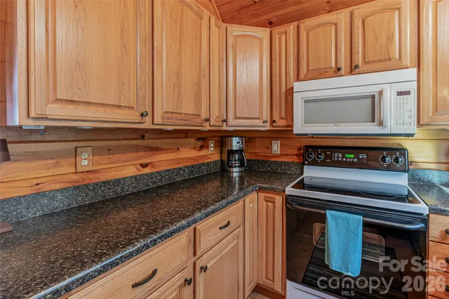 a kitchen with granite countertop a sink a stove and cabinets