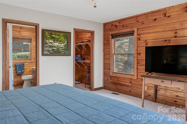 a bedroom with a bed and flat screen tv