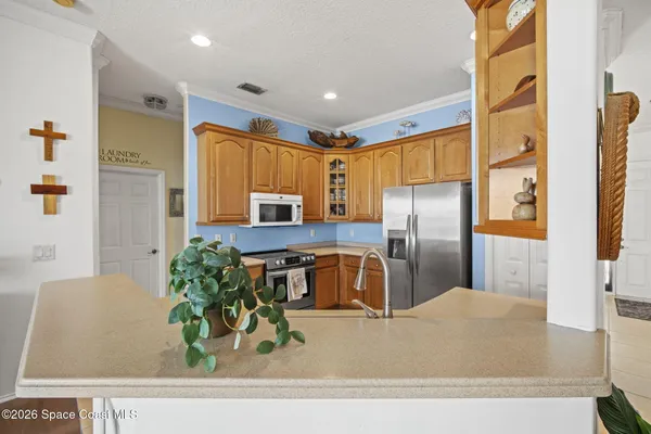 a kitchen with stainless steel appliances granite countertop a refrigerator a stove and a sink