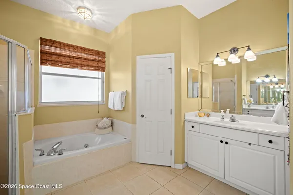 a bathroom with a tub a sink and mirror