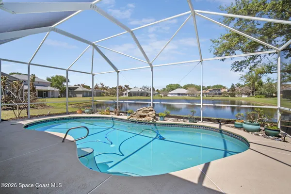 a view of a swimming pool with a yard and sitting area