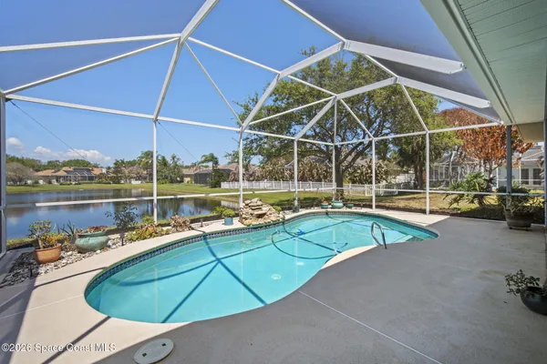 a view of a swimming pool with a patio and a yard