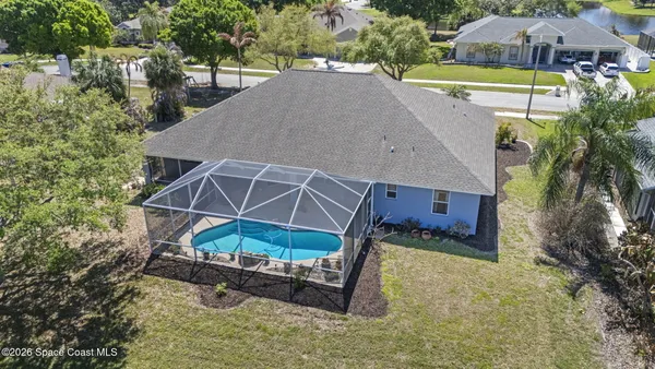 an aerial view of a house with a yard and swimming pool