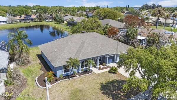 an aerial view of a house with swimming pool and lake view