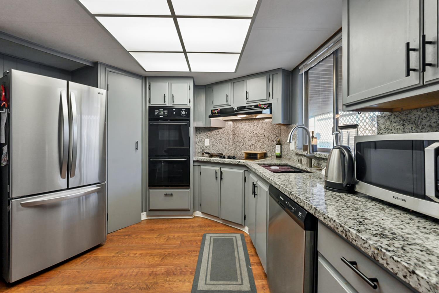 1400 North Tully Road, Unit 137 Turlock, CA 95380 - Photo 11 of 37 a kitchen with stainless steel appliances granite countertop a refrigerator a stove and a sink