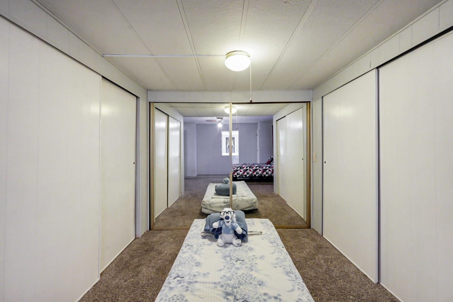 1400 North Tully Road, Unit 137 Turlock, CA 95380 - Photo 27 of 37 a hallway with a large mirror and couches with wooden floor