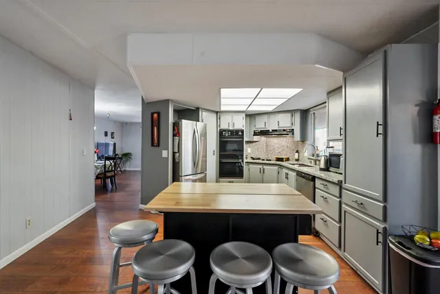 a kitchen with stainless steel appliances a refrigerator sink and microwave