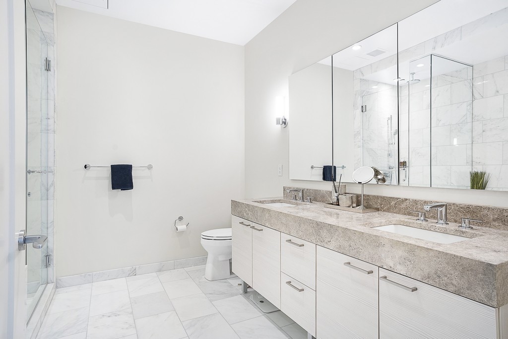 1 Franklin Street, Unit 3701 Boston, MA 02110 - Photo 12 of 26 a bathroom with a granite countertop sink a toilet and a mirror