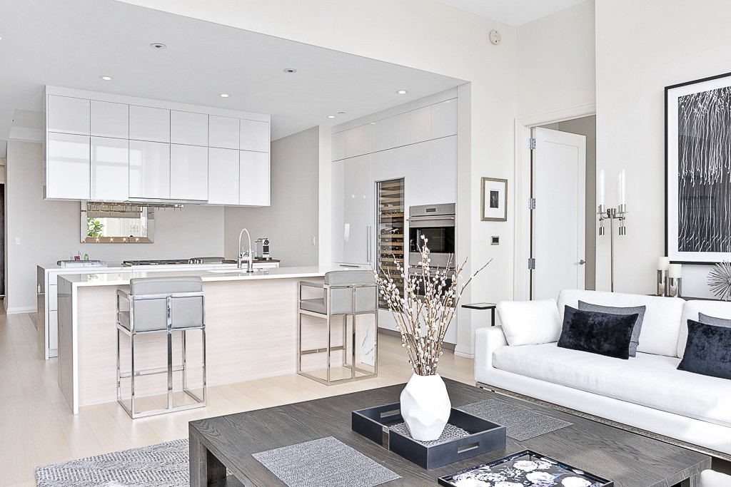 1 Franklin Street, Unit 3701 Boston, MA 02110 - Photo 3 of 26 a living room with white couches and kitchen view with wooden floor