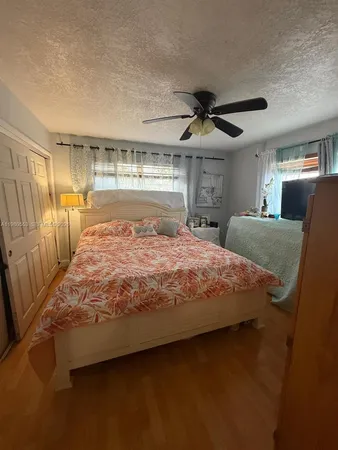 a bed sitting in a bedroom next to a larger window