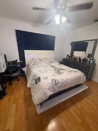 a bedroom with a bed and wooden floor