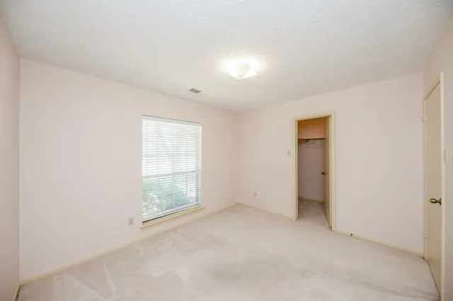 an empty room with windows and closet