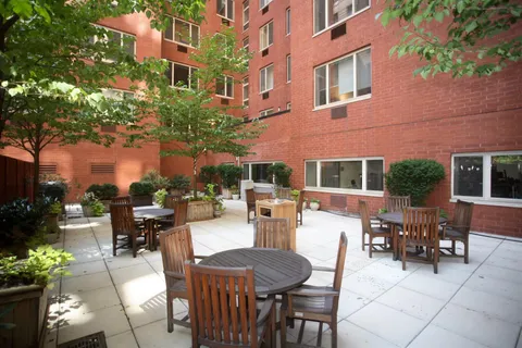a view of a patio with couches table and chairs and potted plants