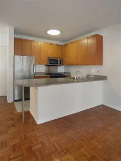 a kitchen with stainless steel appliances a sink a stove a microwave a counter top space and cabinets