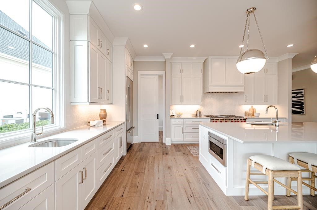 7920 Hardwick Drive Raleigh, NC 27615 - Photo 12 of 53 a large kitchen with cabinets wooden floor and a sink