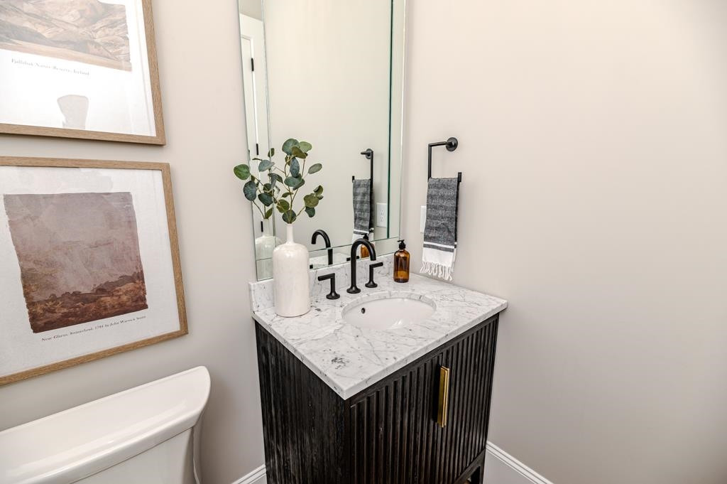 7920 Hardwick Drive Raleigh, NC 27615 - Photo 32 of 53 a bathroom with a granite countertop sink a toilet and a mirror
