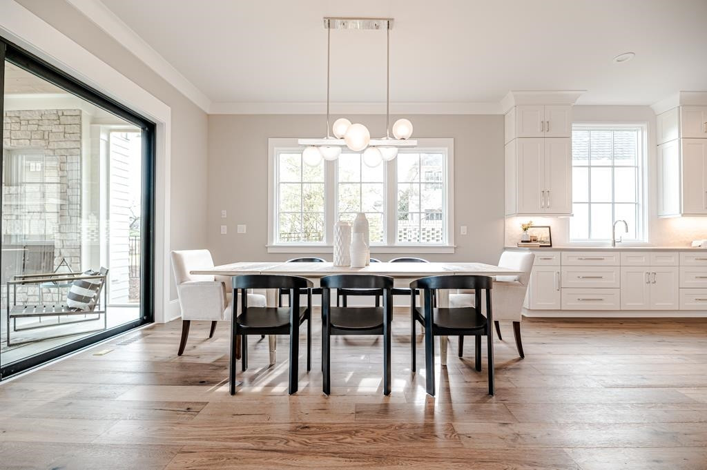 7920 Hardwick Drive Raleigh, NC 27615 - Photo 9 of 53 a dining room with wooden floor a chandelier a wooden table and chairs