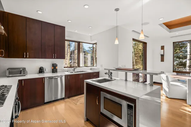 a kitchen with kitchen island stainless steel appliances a stove a sink and a refrigerator