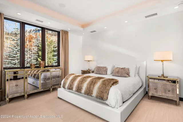 a bedroom with a large window and a bed