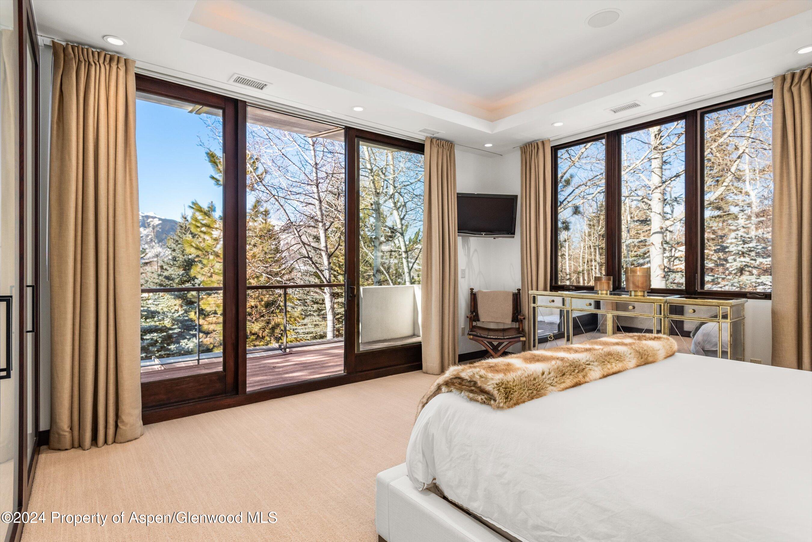 25 Nighthawk Drive Aspen, CO 81611 - Photo 20 of 34 a bedroom with a large bed and a large window with outer view