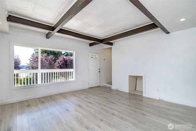 a view of a hallway with wooden floor and a window