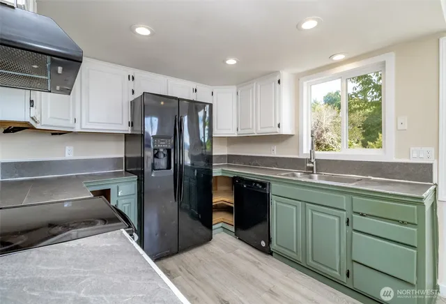 a kitchen with a refrigerator sink and cabinets