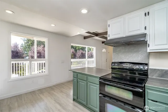 a kitchen with granite countertop a stove and a wooden floors